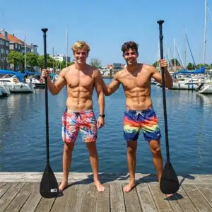 Twee jonge gespierde mannen met SUP-peddels